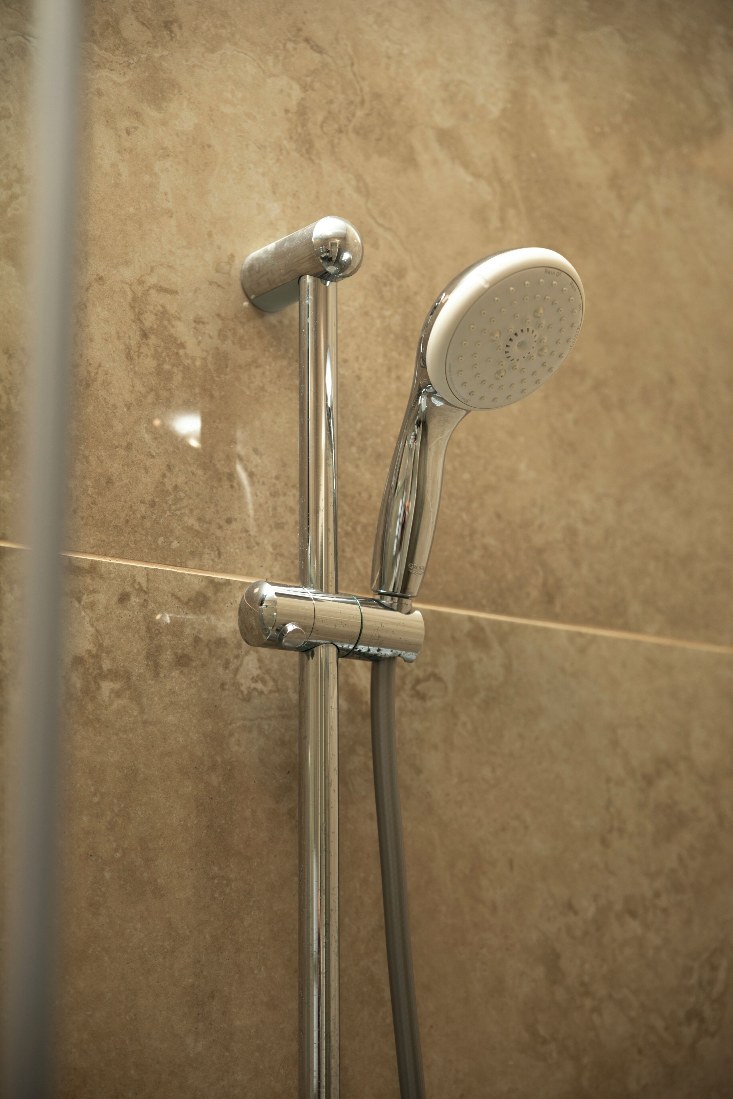 A shower with a handheld showerhead and a fixed wall-mounted showerhead.