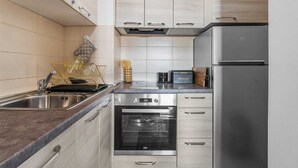 Een moderne keuken met een roestvrijstalen spoelbak, een inbouwoven en een koelkast.