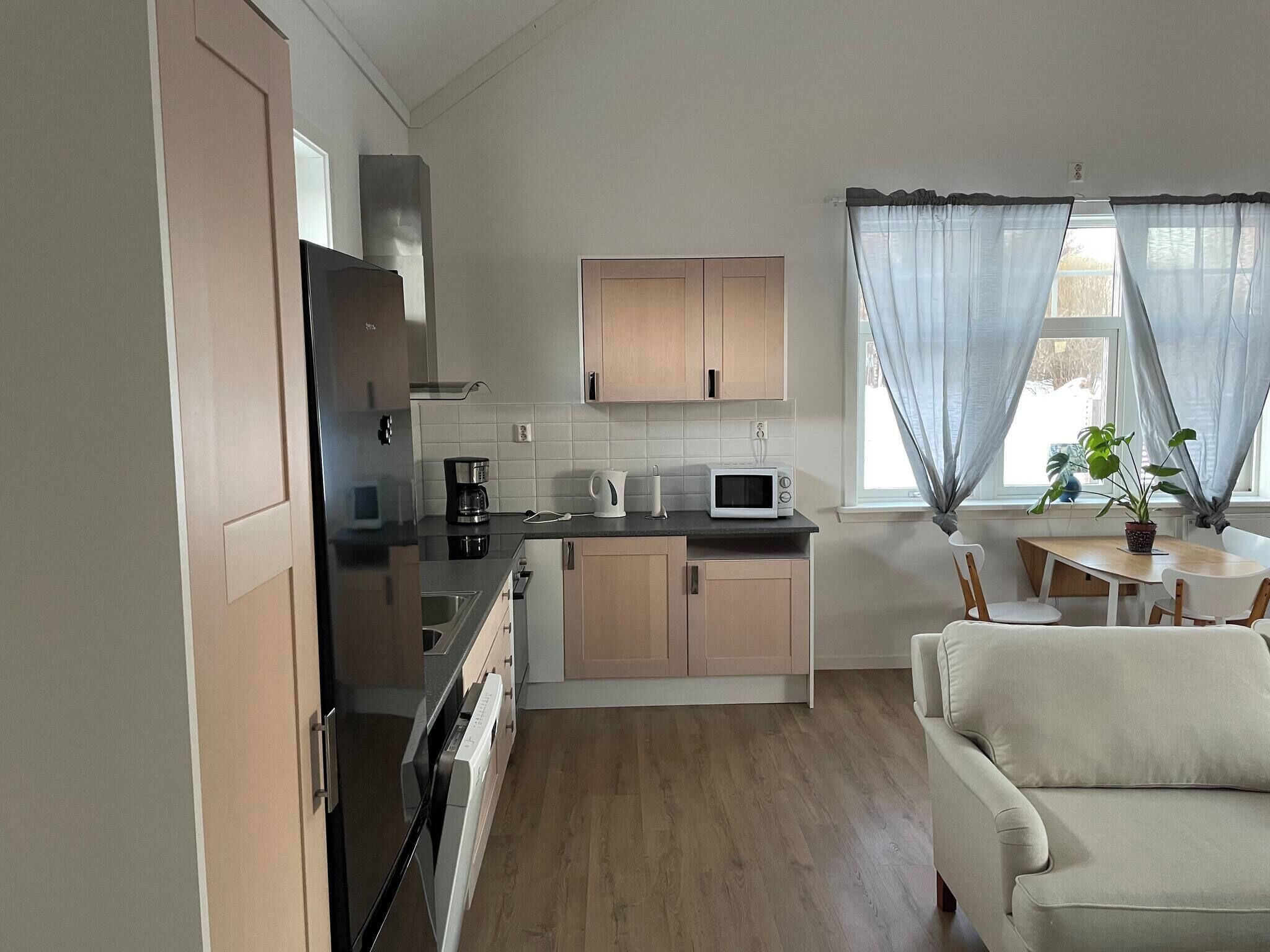 A compact kitchen with a microwave, coffee maker, and a dining area with a table and chairs.
