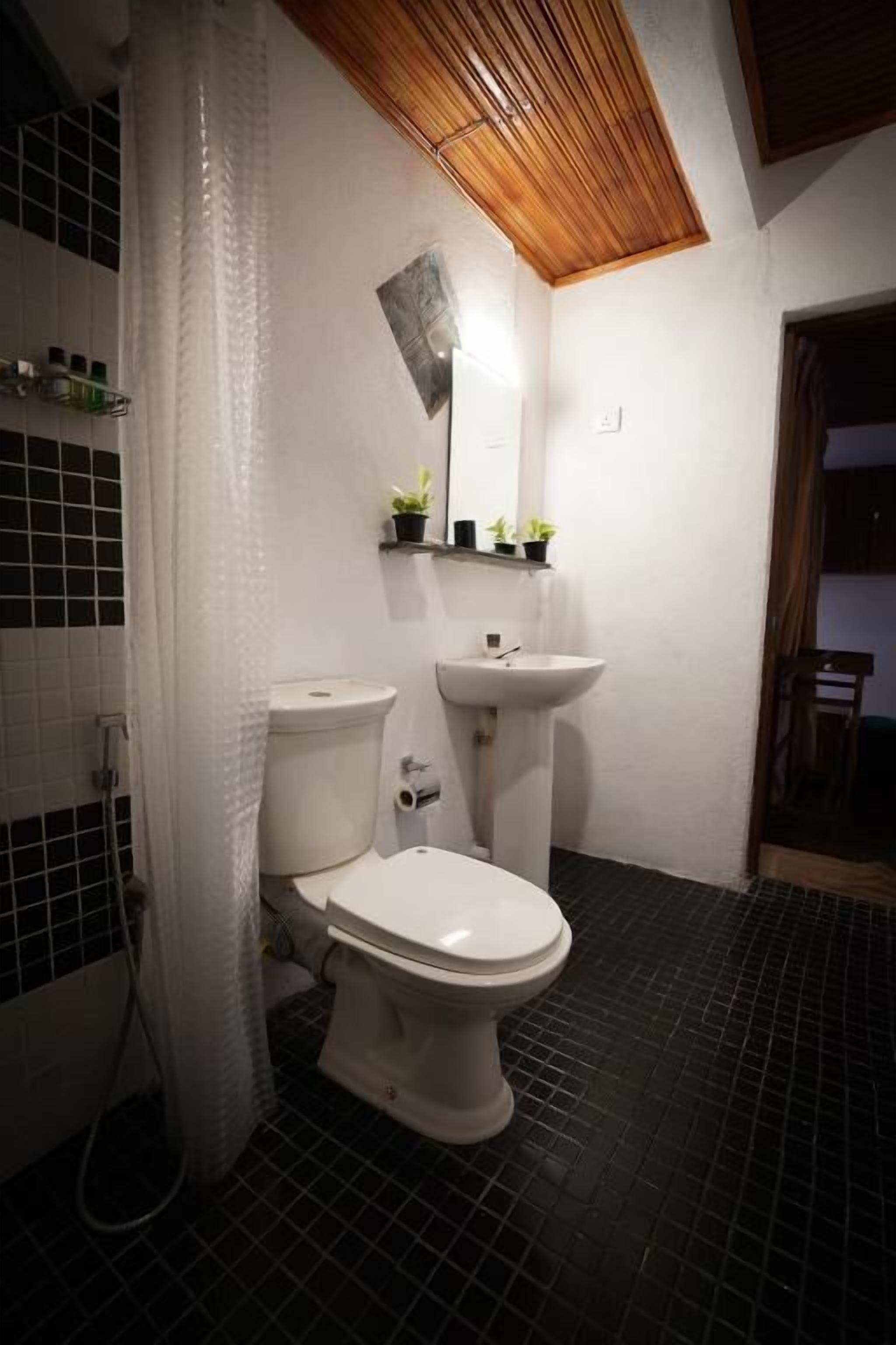 A bathroom with a toilet, sink, and shower area.