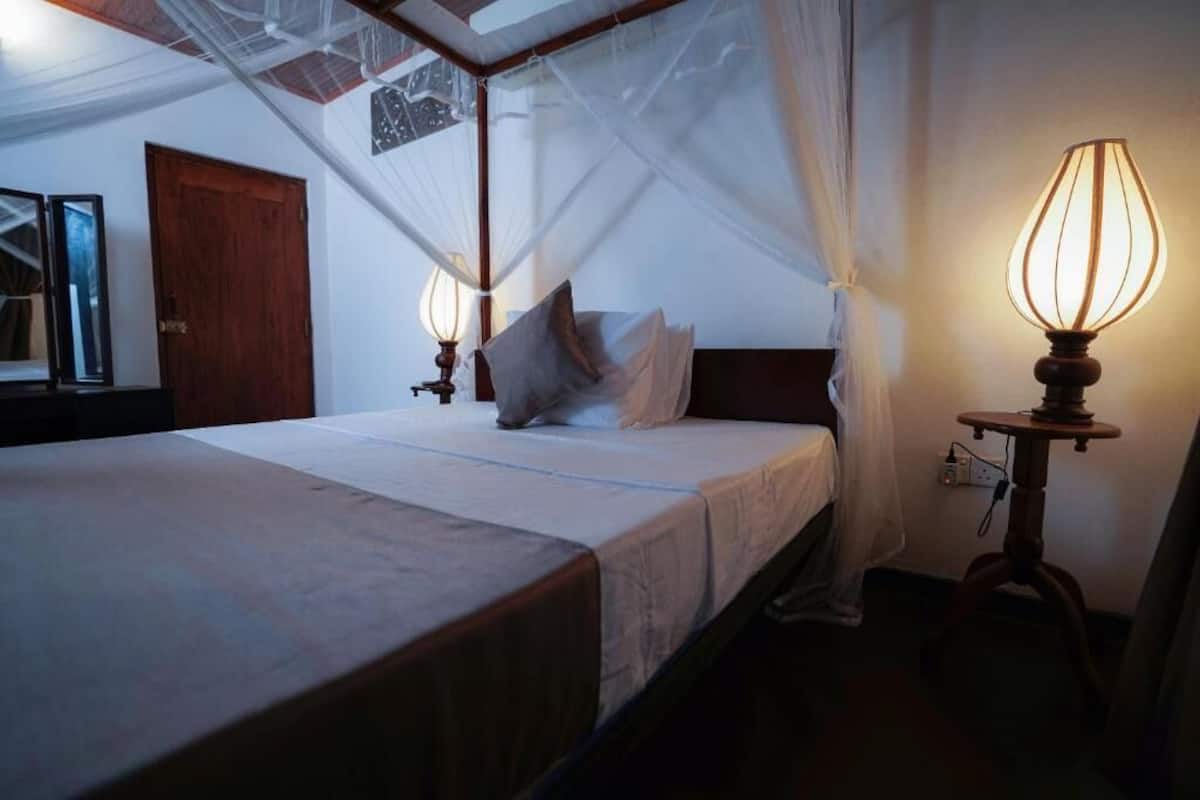 Une chambre à coucher avec un lit à baldaquin, des lampes de chevet et une table de chevet.