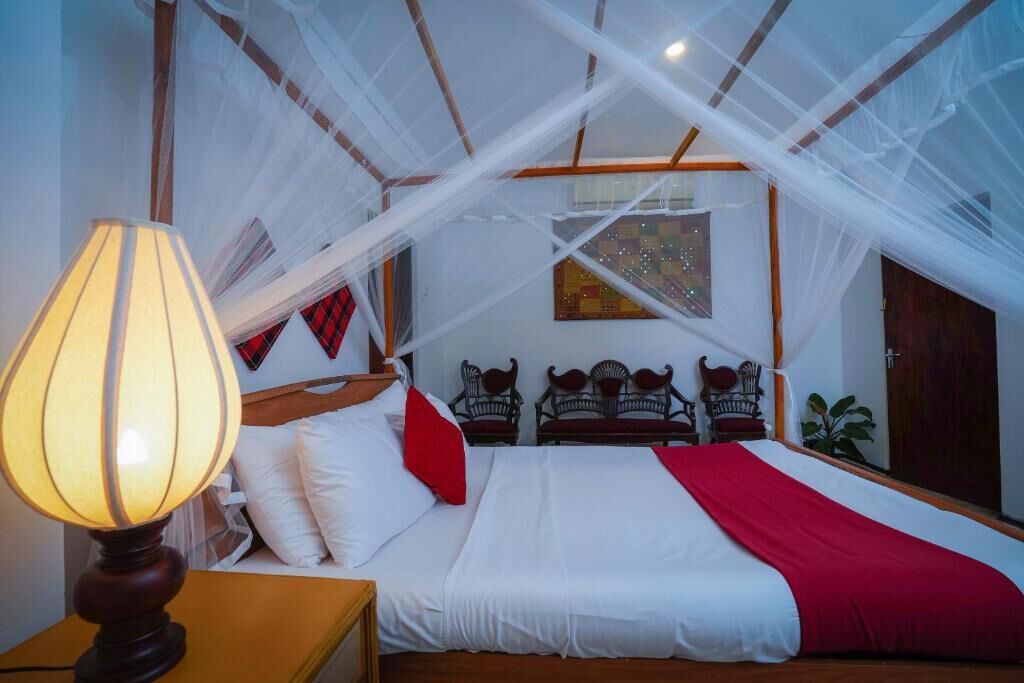 Ein Schlafzimmer mit einem Bett, einem Nachttisch, einer Lampe und einem Fenster mit Ausblick.