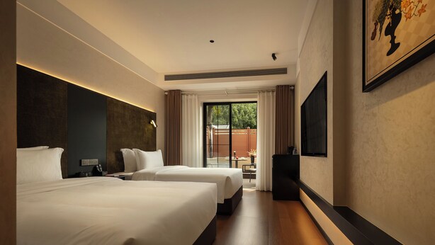 A hotel room with two beds, a TV, a desk, and a view of the outdoors. - Zhangjiajie JIMO HOTEL (Zhangjiajie)