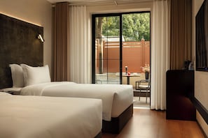 A hotel room with two beds, a desk, a chair, and a view of the outdoors. - Zhangjiajie JIMO HOTEL (Zhangjiajie)