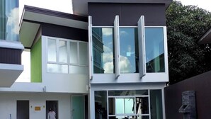 En modern byggnad med en swimmingpool, stora fönster och en person som befinner sig nära poolen.