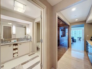 Un baño moderno con encimera de mármol, un espejo grande y un inodoro.