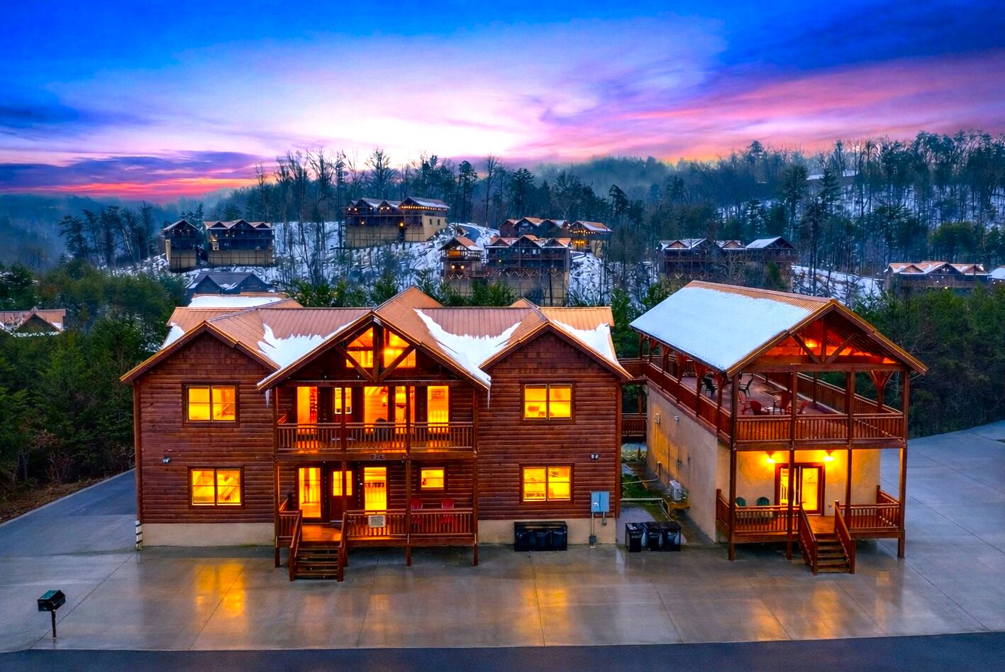 Golden-hour mountain retreat glowing at dusk, with expansive decks, cozy cabin charm, and sweeping Smoky Mountain views in every direction.