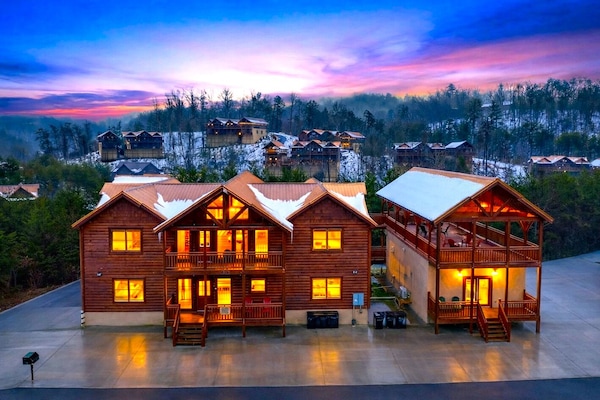Golden-hour mountain retreat glowing at dusk, with expansive decks, cozy cabin charm, and sweeping Smoky Mountain views in every direction.