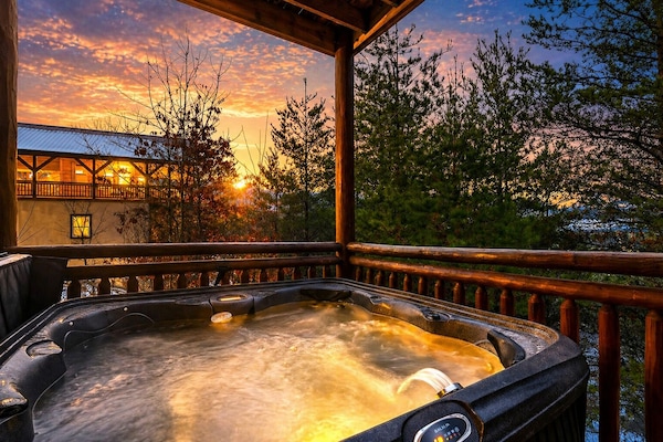 Unwind in the private hot tub as the Smoky Mountains glow at twilight—peaceful forest views, crisp mountain air, and the perfect spot to relax after a day of adventure.