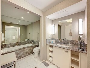 Een moderne badkamer met een ruime wastafel, een apart toilet en een douchehoek.