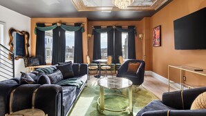 A modern living room with a sofa set, a round coffee table, and a chandelier. - Hottub + Speakeasy Lounge + Premium Karaoke + Rooftop + Near Downtown Nashville (Nashville)