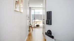 A modern hallway with a sleek door featuring a keypad lock and a handle. - Relax by the Beach, Close to Everything - Minutes from City & Airport! (Flinders Park)