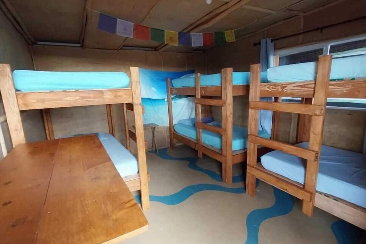 A compact cabin with bunk beds, a wooden table, and a ceiling fan.