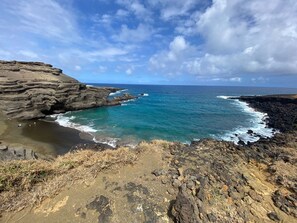 A coastal landscape with rocky cliffs and a clear view of the ocean. - Open Gate Hostel Hawaii (Pāhoa)