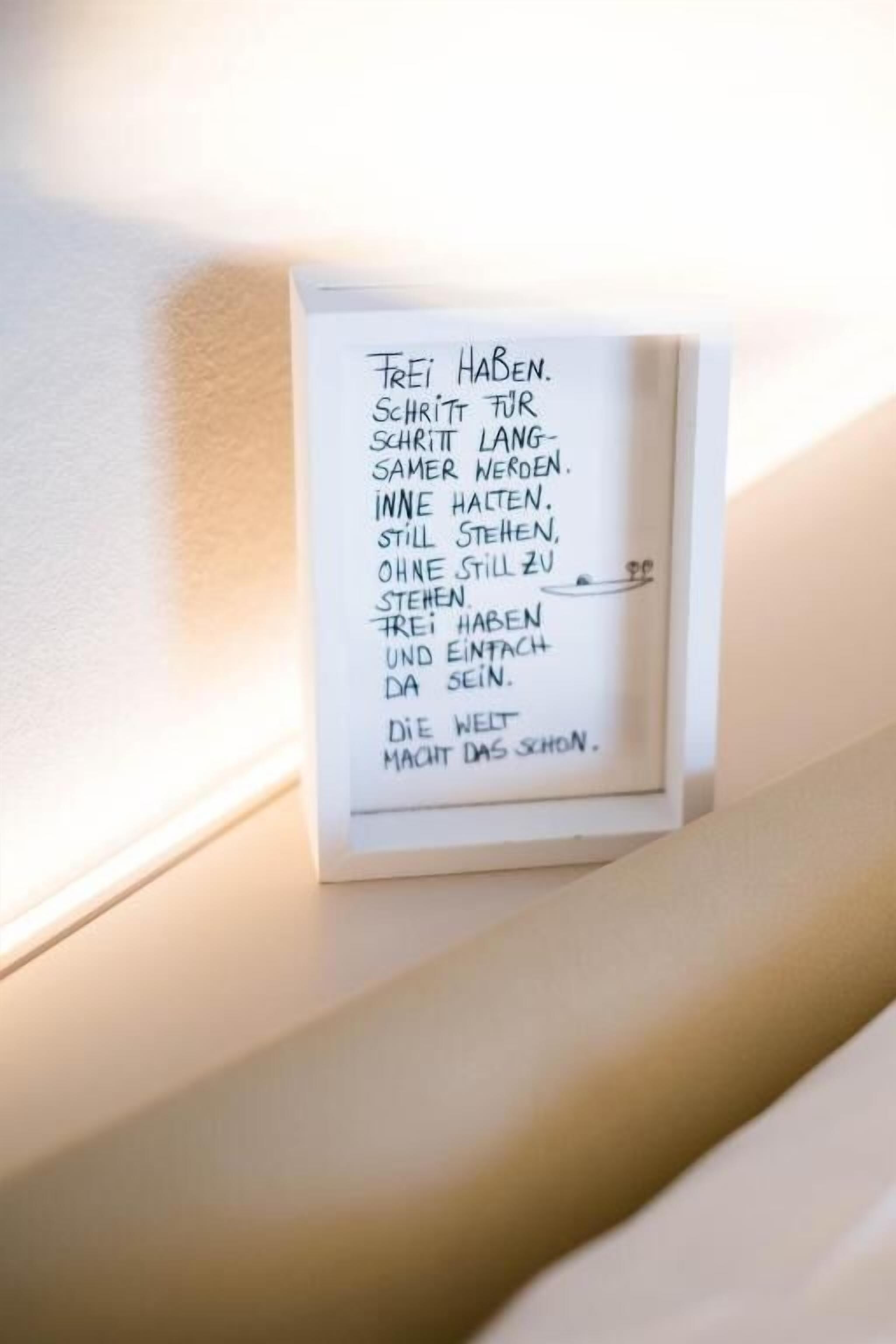 A framed handwritten note on a wall.