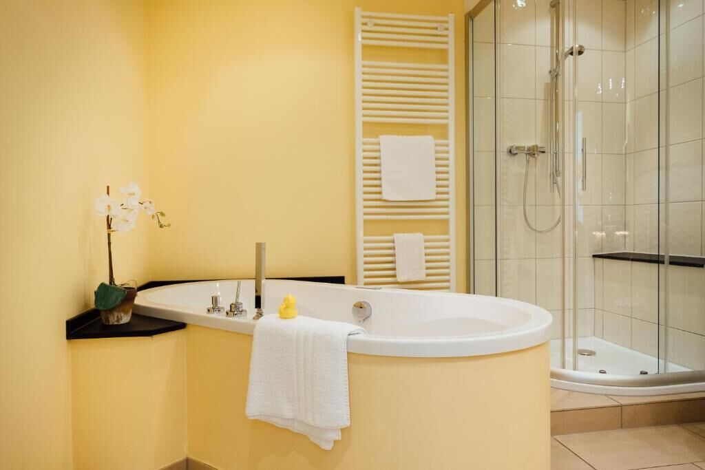 Un baño con bañera, ducha y barra para toallas.