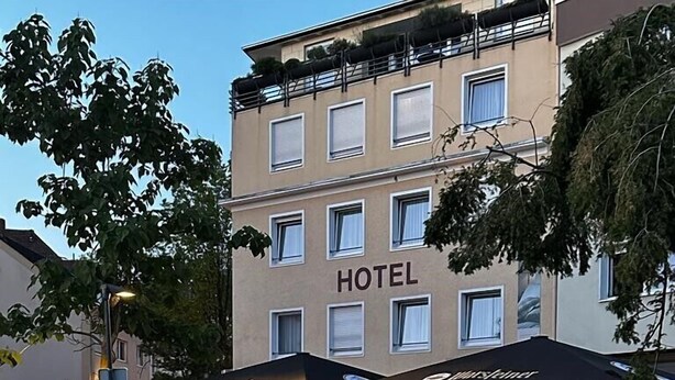 A hotel with outdoor seating and a canal in front. - Hotel zur Mühle (Paderborn)