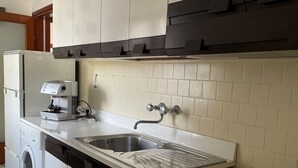 Una cocina con lavadora, estufa y fregadero.