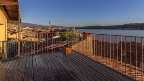 Una terraza de madera con vistas a un paisaje urbano y un río.