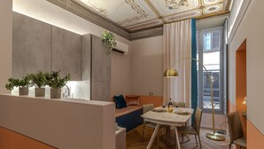 Un comedor moderno con suelo de madera, una mesa blanca y un sofá azul.