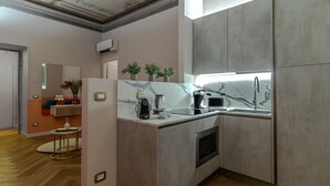 Una cocina moderna con horno empotrado, un fregadero y encimera de mármol.