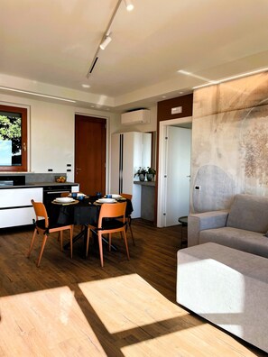 Ein modernes Wohnzimmer mit einer grauen Couch und einem Essbereich mit Tisch und Stühlen.
