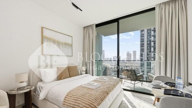 Ein modernes Hotelzimmer mit einem großen Bett, einem Schreibtisch und einem Balkon mit Blick auf die Stadt.