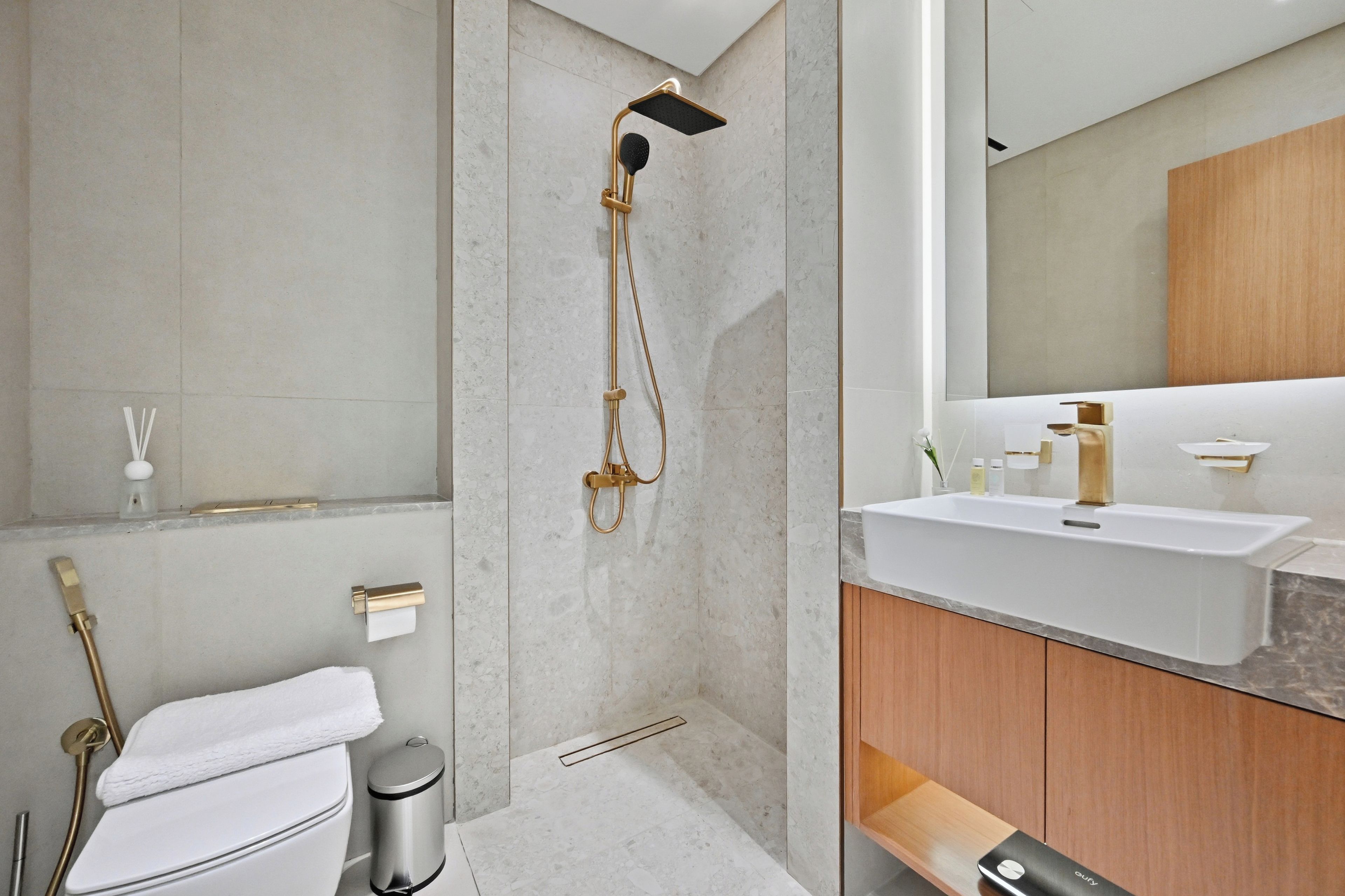 A modern bathroom with a shower, toilet, and vanity.