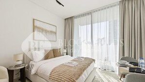 Ein modernes Hotelzimmer mit einem großen Bett, einem Schreibtisch und einem Stuhl.
