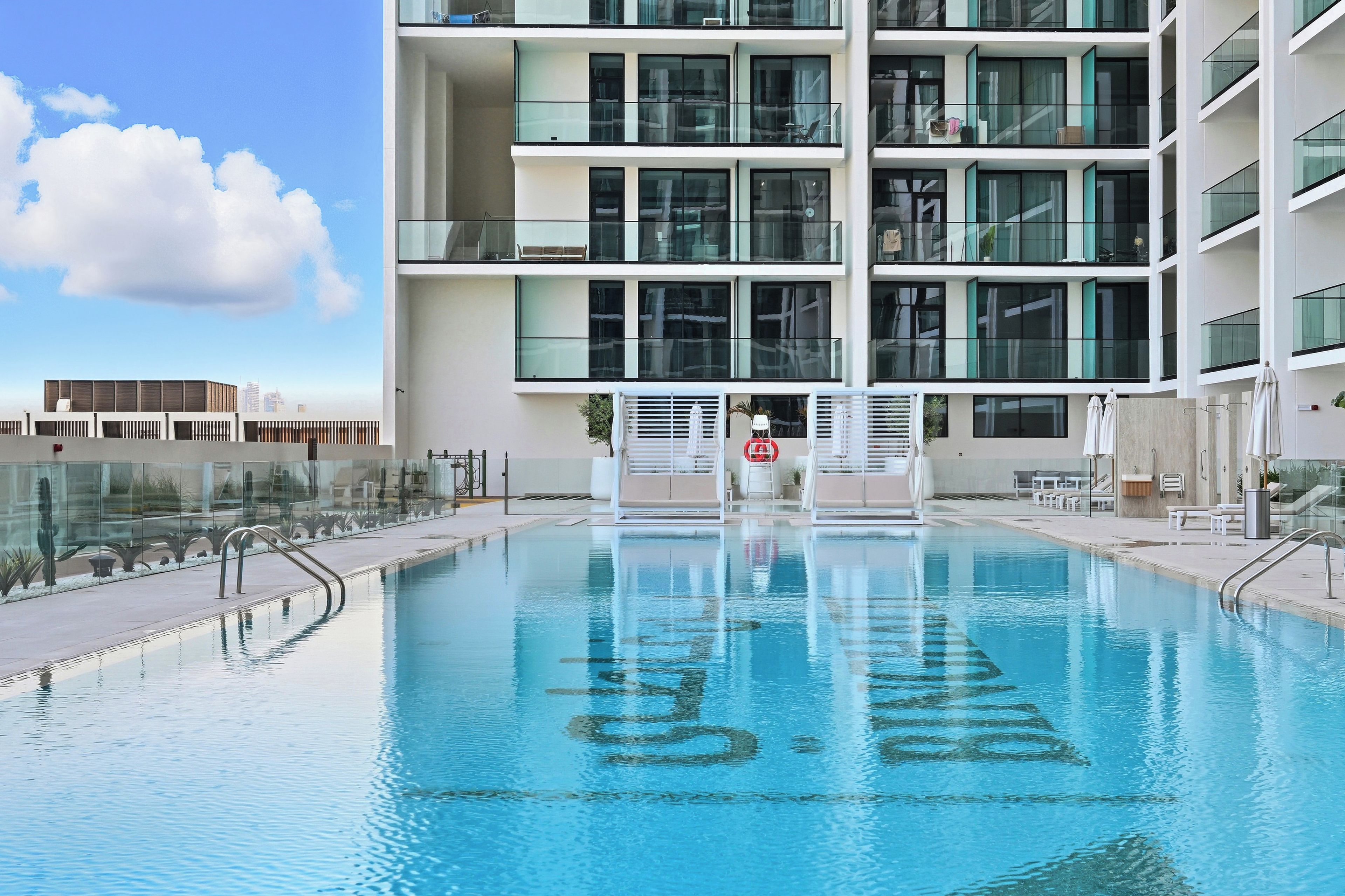 A modern building with a swimming pool in front.