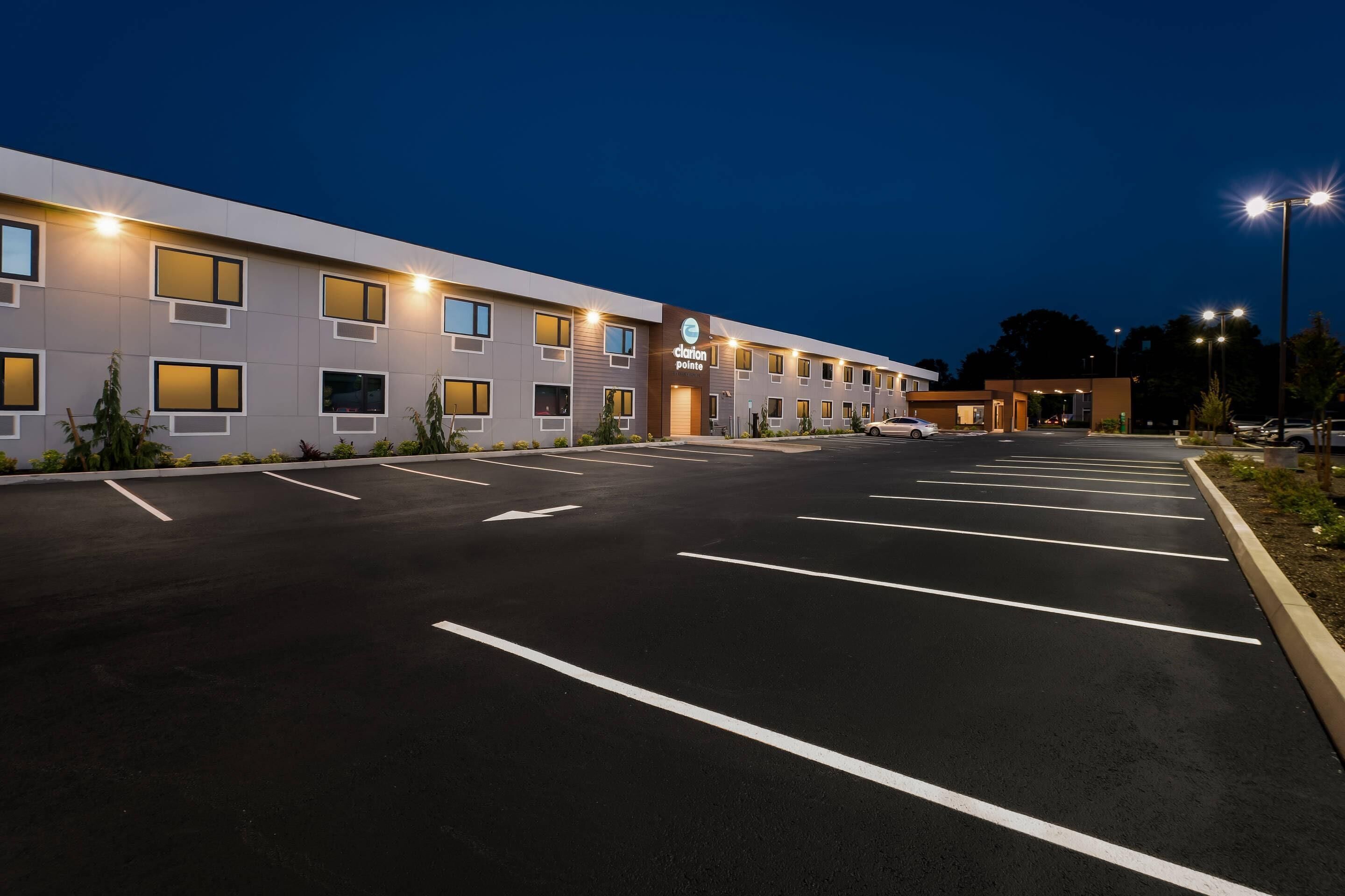 A hotel with a row of rooms, a parking lot, and a sign indicating 'Clarion Point.'