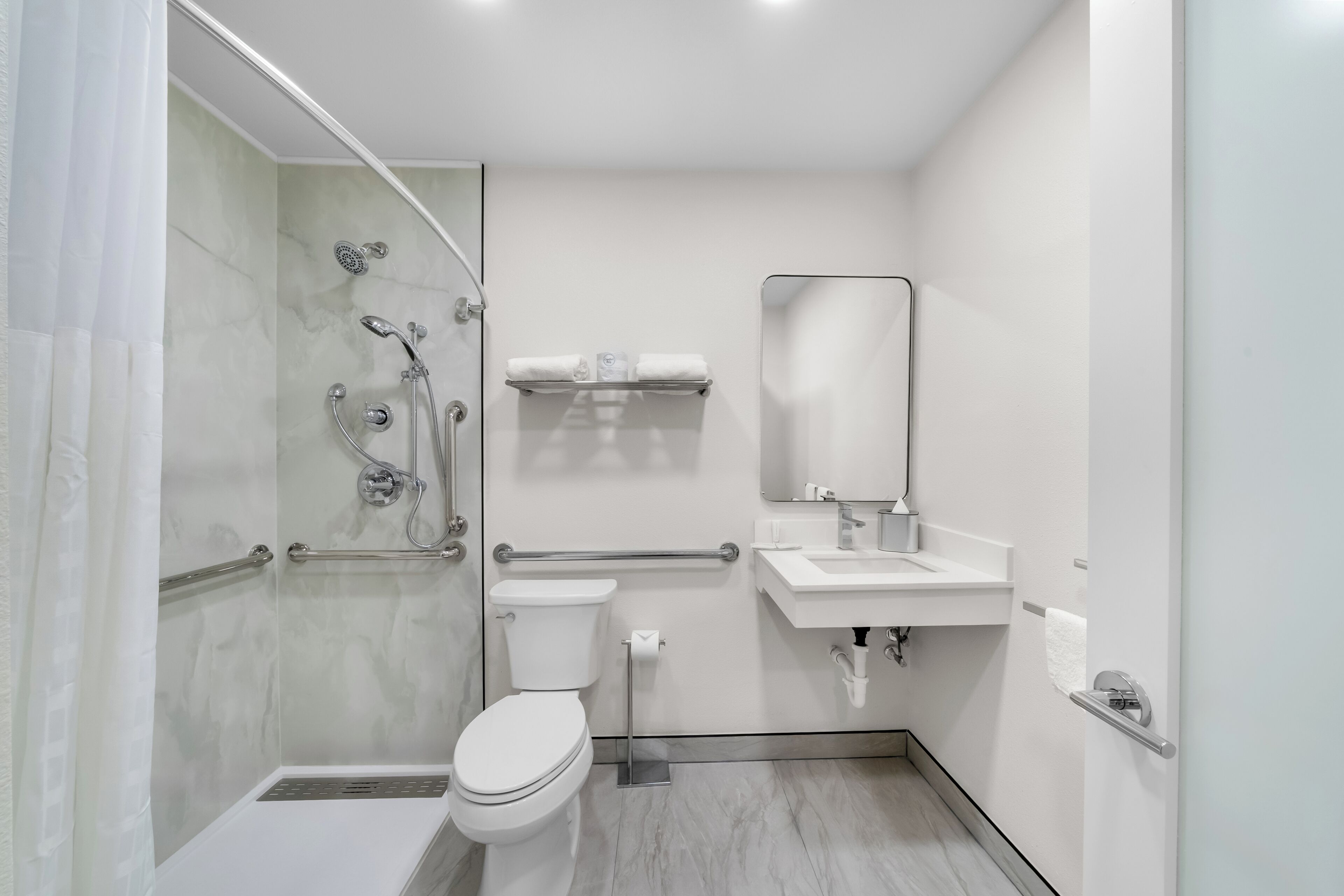 A modern bathroom with a shower, toilet, sink, and a glass-enclosed shower area.