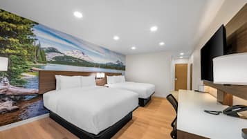 A hotel room with a large bed, two bedside tables, a desk with a phone, and a TV.