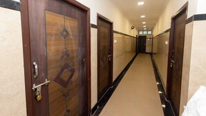 A hallway with wooden doors, a carpeted floor, and a ceiling with recessed lighting.