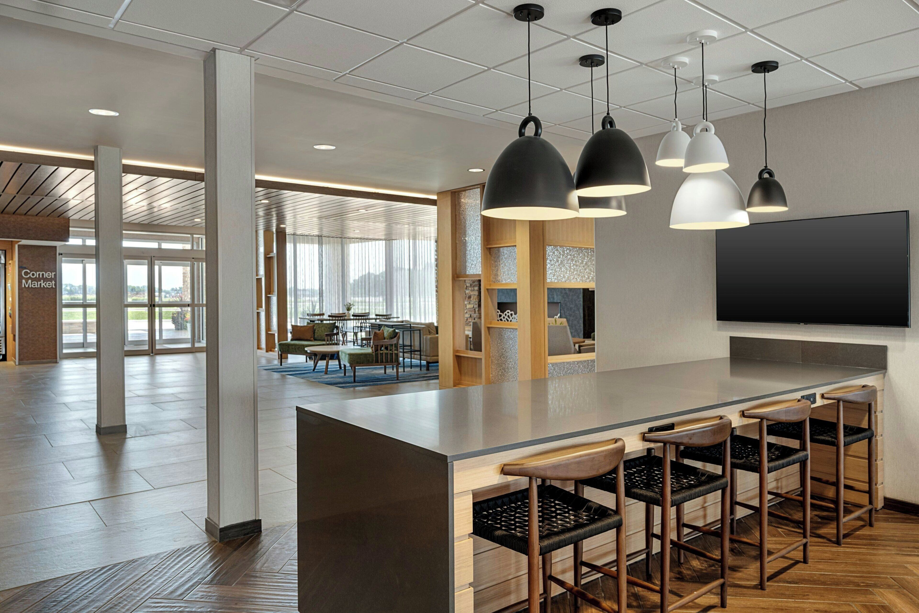 A modern interior with a bar area, seating, and a large flat-screen TV.