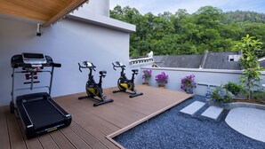 A rooftop gym with exercise equipment, a small pool, and surrounding greenery. - Fenghuang Story Hotel (Xiangxi)
