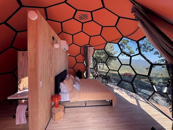 Un dormitorio con cama, cabecero de madera y vistas al exterior.