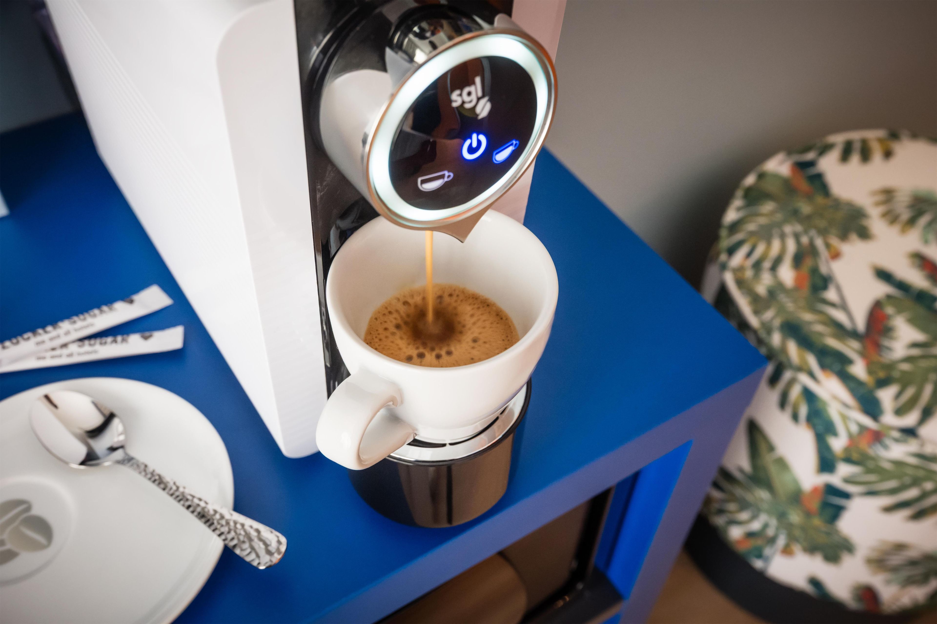 Una máquina de café vertiendo café en una taza.