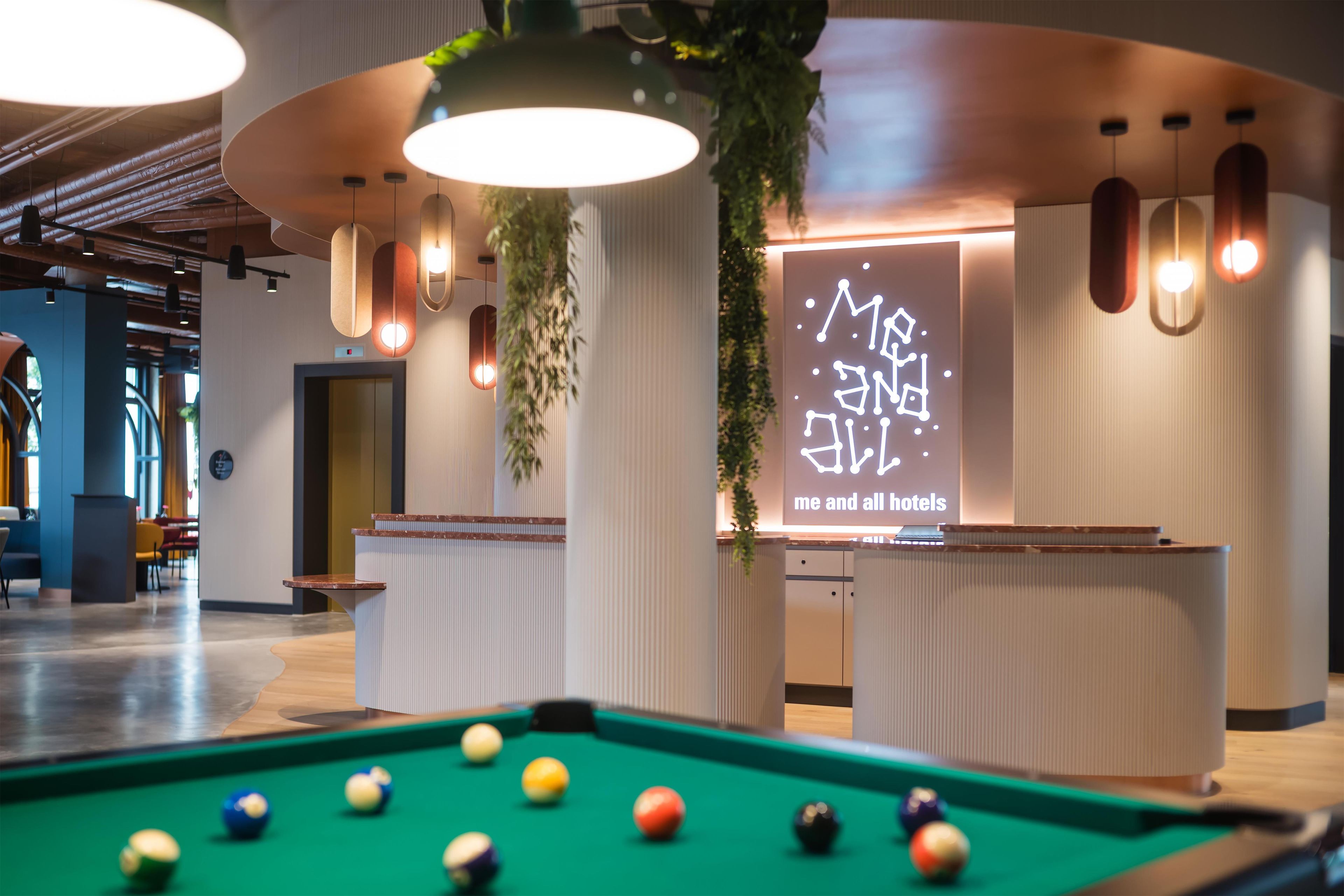A pool table in a hotel lobby with a projection screen displaying text.