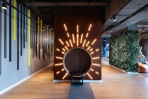 A modern interior with a circular wall feature and a seating area. - Me and All Hotel Leipzig, by Hyatt (Leipzig)