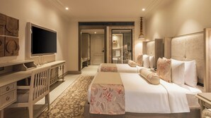 A hotel room with a bed, a desk, a television, and a bathroom visible through an open door. - The Evren, Vagator (GOA)