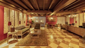 A spacious living room with a checkered floor, a sofa, a coffee table, and a fireplace. - The Evren, Vagator (GOA)