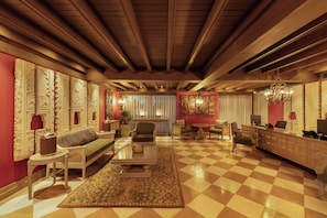 A spacious living room with a checkered floor, a sofa, a coffee table, and a fireplace. - The Evren, Vagator (GOA)
