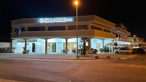 A hotel with a prominent sign, multiple floors, and a covered entrance area. - GLOBAL HOTEL (San Ferdinando)