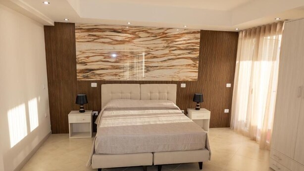 A modern bedroom with a large bed, two bedside tables, and a marble-patterned wall. - GLOBAL HOTEL (San Ferdinando)