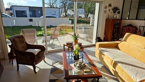 Un salon comprenant un canapé, un fauteuil et une table basse agrémentée d’objets décoratifs.