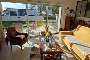 A living room with a sofa, armchair, and a coffee table with decorative items. - Ground floor holiday home in Plestin des Grèves (Plestin les Grèves)