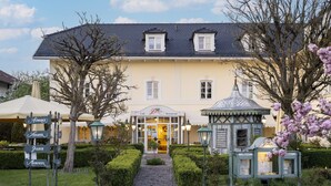 Ein Gebäude mit Café und Restaurant, ein Kopfsteinpflasterweg und ein kleines Gazebo.