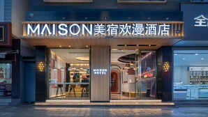 A modern hotel entrance with a prominent sign, glass doors, and a reception area visible inside. - Lijiang MAISON Hotel (Lijiang)