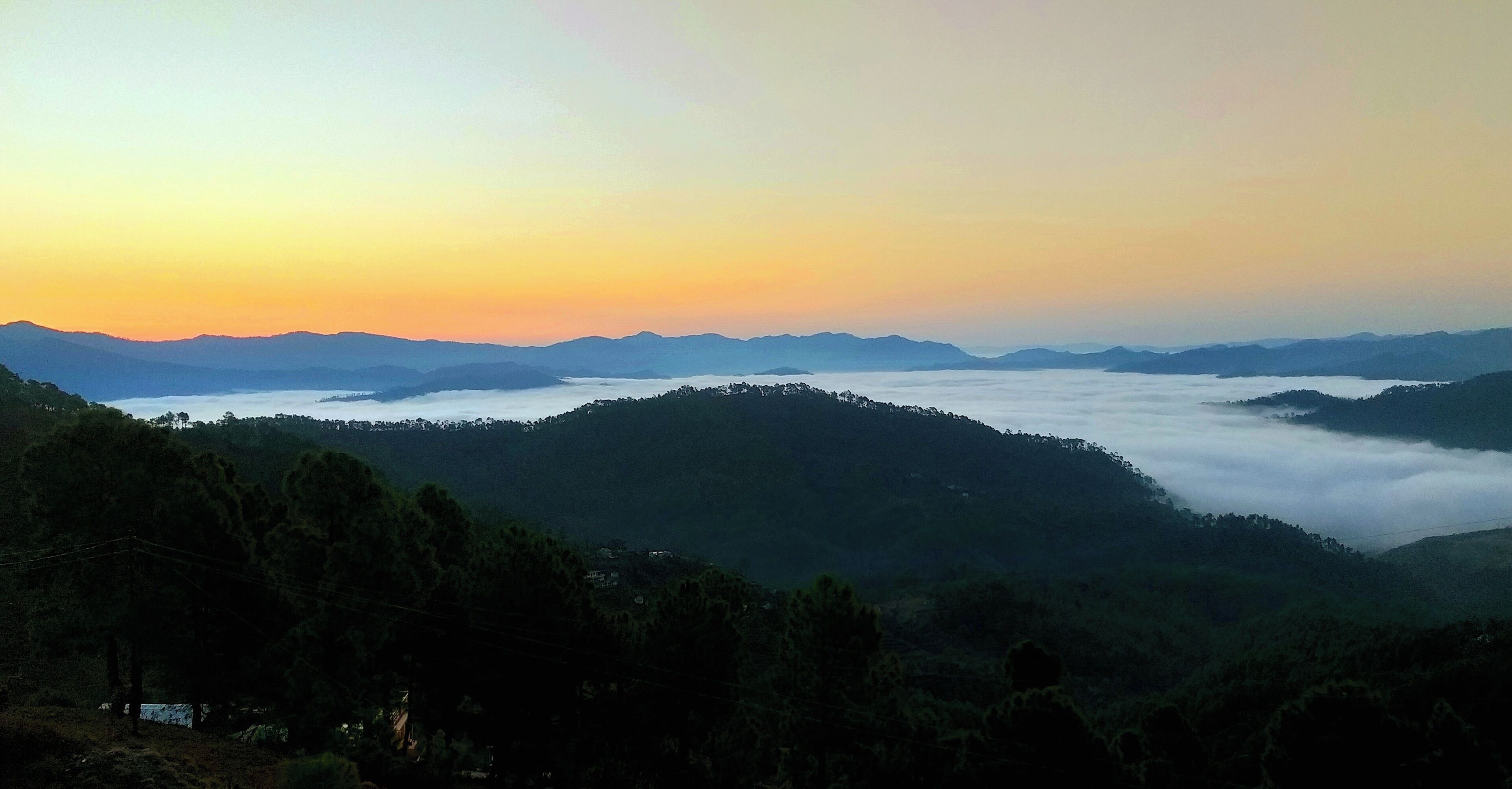 A mountainous landscape with a valley and a body of water at the base.